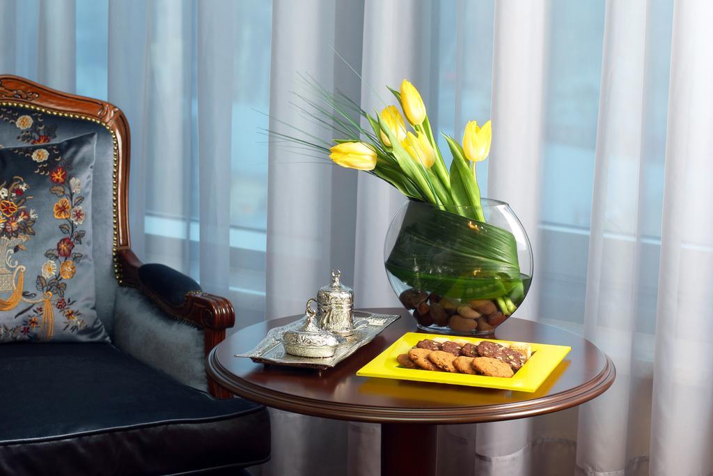 Orion Hotel Bishkek Esterno foto A table with a vase of flowers